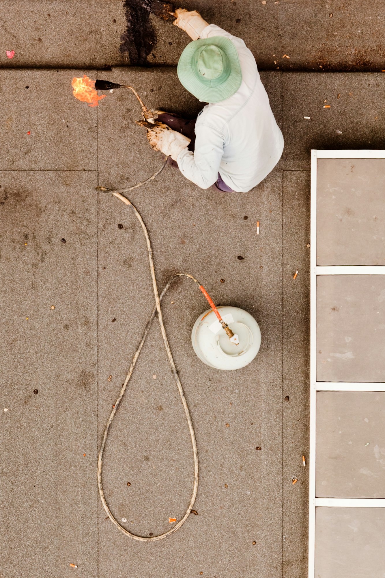 Roofer using propane torch to repair flat roof